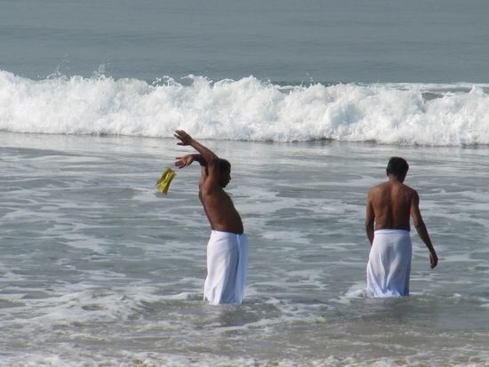 Es läuft hier etwa so ab (so von mir beobachtet, ohne Garantie): 
- weißes Tuch anziehen (bekommt man preiswert geliehen)
- knieen
- dreimal mit der rechten Hand um den Kopf
- aufstehen
- dreimal um die eigene Achse drehen
- knieen
- Bananenblatt mit Reis entgegennehmen
- aufstehen
- Bananenblatt im Sand am Strand auslegen (die Raben freuen sich)
- knieen, aufstehen
- neues Bananenblatt mit Blüten
- dies auf dem Kopf zum Meer tragen
- mit dem Rücken zum Meer das Bananenblatt hinterrücks fallen lassen
- bezahlen.
So weit, so gut. Aber fremd. Auch Katholiken und Evangelen haben ihre Rituale. Und kein Hindu würde einen Andersgläubigen als Ungläubigen bezeichnen.
PS. Wir hatten - Gott sei Dank - noch unser Puja-Bändchen aus dem heiligen Ort Pushkar und wurden kaum angesprochen.