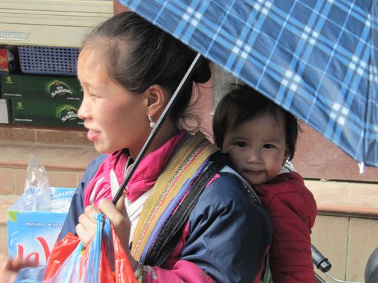 Hmong Frauen, die gerne ihre Handarbeiten verkaufen. Immer mit Kindern.