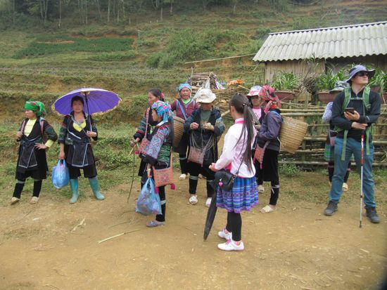 Unserer Touristengruppe angeschlossen haben sich einige Hmong-Frauen, die in ihr Dorf wollen. Jede von ihnen hat sich einen Fremden ausgesucht und hilft an den schwierigen, steilen, zum Teil glitschigen Stellen.