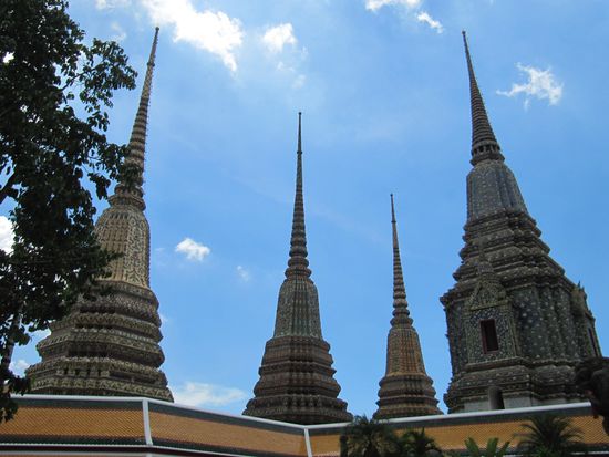 Wat Pho im Zentrum der historischen Altstadt von Bangkok. Weithin sichtbar durch die vier Chedis, eine jede 42 Meter hoch und mit verschiedenfarbigen Mosaiken aus Kacheln bedeckt.
