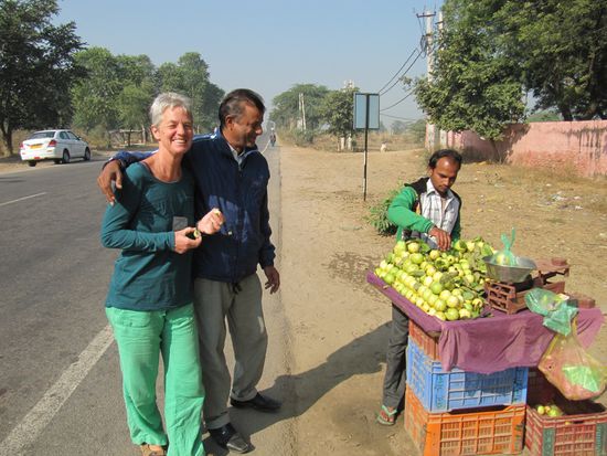 Auf dem Weg nach Mandawa beim Probieren von Guajava-Früchten, mit Kishori und Auto im Hintergrund.