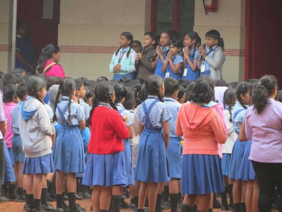 ...Kinder gehen zur Schule, vor Unterrichtsbeginn wird gebetet...