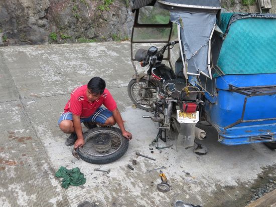 ... und bei Gelegenheit auch mal sein Tricycle repariert. Wir fahren dann mit einigen netten Filipinos, die wir anhalten, in einem dicken Pickup wieder zurück ins Dorf und genehmigen uns im Cafe an der Hauptkreuzung gefüllte Teigballen.