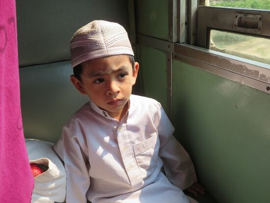 Kleinere Fahrgäste sind über die komischen Touristen erstaunt, die gegenüber sitzen und Bonbons verteilen.