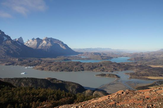 Zu unseren Füßen der Lago Grey - die hellen Tupfer sind Eisberge vom Grey Gletscher, die wie kleine Schiffchen über den See treiben. Im Hintergrund der Lago Peohe und die Cuernos del Paine.