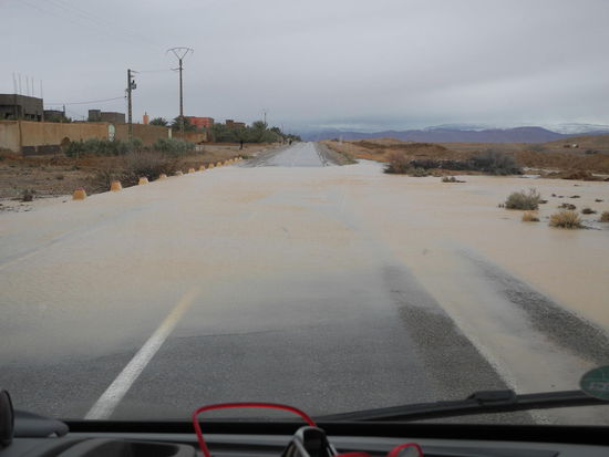 Wasser, Wasser, die Straßen sind überflutet und in der Ferne sehen wir schon die schneebedeckten Berge.