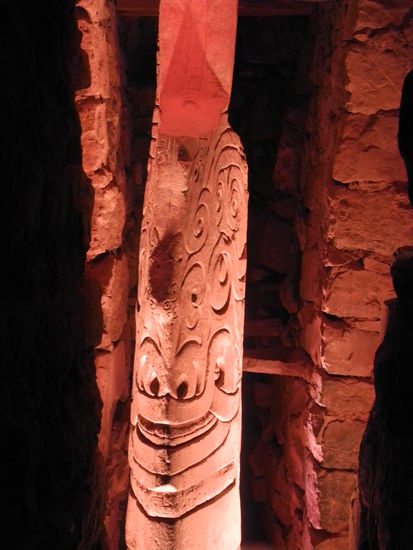 In einem schmalen, dunklen Schacht steht diese lanzenförmige Stele.