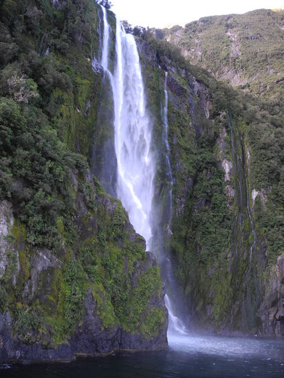 Der Kapitän fährt so nahe an den Wasserfall heran, bis das Wasser auf das Deck prasselt.