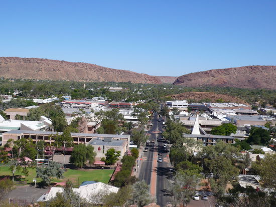 Alice Springs von oben, im Hintergrund die McDonnel Ranges, ein Gebirgszug. Hier gibt es einen engen Durchgang, welcher die östlichen Berge und die westlichen voneinander trennt.