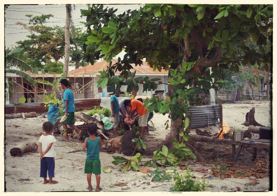 Spannferkel am Spiess - die Kinder schauen interessiert zu wie die Erwachsenen das Ferkel bestreichen. Das nächste "Opfer" stand auch schon bereit, versteckt sich auf dem Bild aber hinter dem Baum.