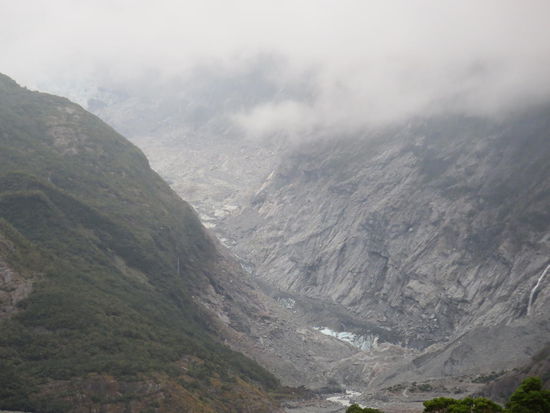 Die Gletscherzunge des Franz-Josef-Gletschers (etwas weit weg), benannt nach dem damaligen Kaiser Österreich-Ungarns (gerade noch, bevor der Regen kam)