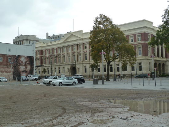Ein frisch renoviertes Gebäude und ein leerer Platz, auf dem mal Häuser standen - hinter mir standen "Häuserwracks" 