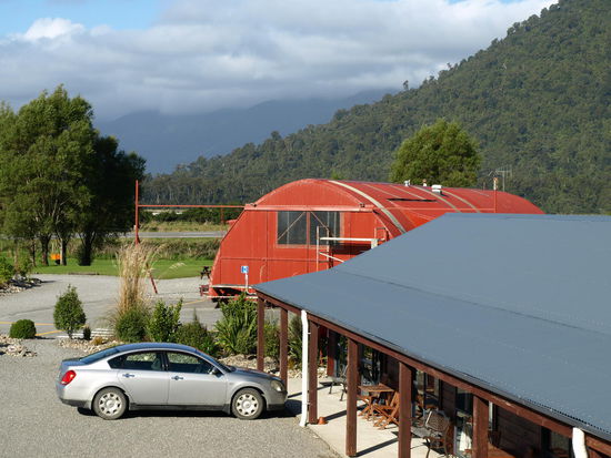 Der Blick  von meiner Veranda auf einen ehemaligen Flugzeughangar, der jetzt die Küche und Co für die Camper bildet 