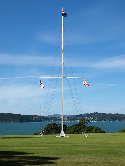 Der Flaggenmast zeigt die Maoriflagge und die britische Flagge vereint nebeneinander unter der Flagge Neuseelands. Der Standort des Mastes soll die Stelle der Vertagsunterzeichnung markieren