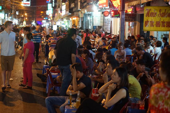 In vierer Reihen sitzen die Tourusten auf der Strasse, gegenueber die Vietnamesen.