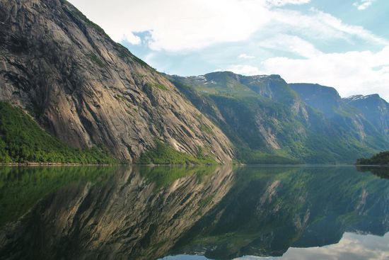 aud dem stillen Wasser spiegeln sich die rauen Felsen
