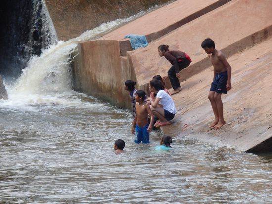 Einheimische Kinder spielen und angeln im kühlen River.