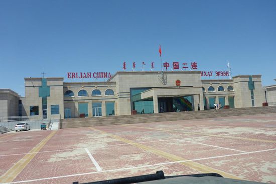 Im Zollhof nach Passieren der mongolisch-chinesischen Grenze.
24. 7. 2014, Tag 71, 12 593 km
179 Stunden reine Fahrzeit, 322 Stunden am Steuer (mit Standzeiten)
Durchschnittsgeschwindigkeit 58 kmh, kmh-max. 118
Wir warten hier einige Stunden auf die Freigabe durch die Behörden.
Ein Mitreisender muß die Weltkarte am Heck seines Fahrzeugs entfernen,
sie zeigt Grenzverläufe, die den chinesischen Vorstellungen offensichtlich widersprechen