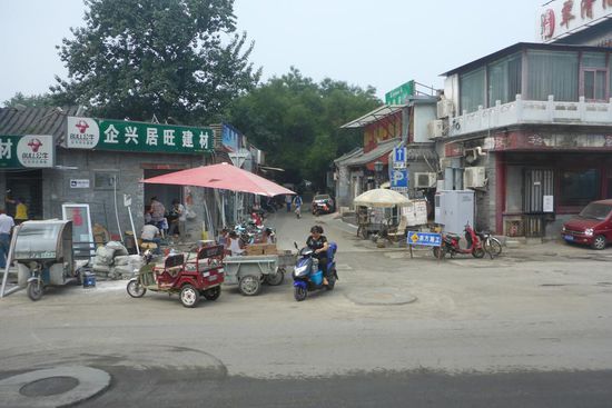 Die traditionellen Wohnviertel müssen weichen:
Das ist in China unproblematisch, sämtlicher Grund und Boden gehört dem Staat;
Im Staatsinteresse wird kompromisslos in weit entfernte und anonyme Hochhäuser umgesiedelt, unter Aufgabe der gewachsenen sozialen Strukturen mit allen negativen Implikationen