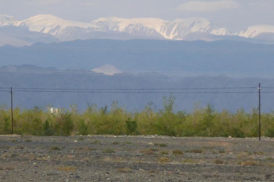 Stellplatz in der Wüste bei Hami vor schneebedeckten Bergen ...