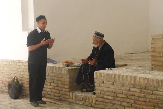 Ein Gläubiger sucht den Segen eines Hodschas am Rand des Basars