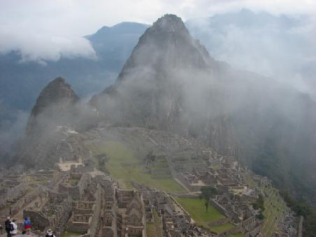 Langsam laesst die Sonne die ganze Pracht Machu Picchus erkennen. Im Hintergrund rechts der Waynapicchu.
