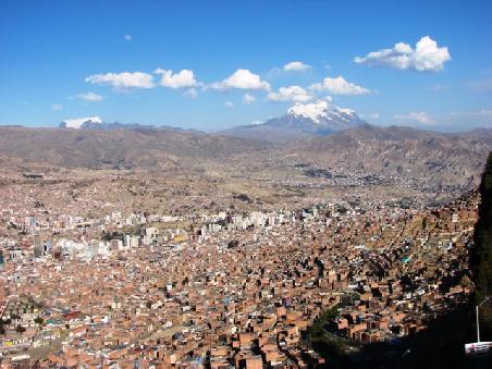 Im Zentrum von La Paz wurden zahlreiche Hochaeuser errichtet. Bis heute leben links davon die Weissen, auf der rechten Seite die Indigenas. Im Hintergrund ragt der 6439 m hohe Illimani auf.