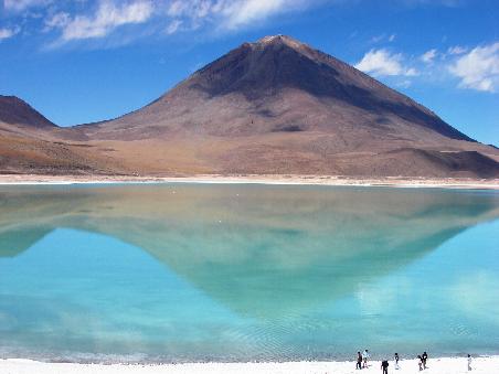 Der Licancabur, der die Grenze zu Chile darstellt, spiegelt sich im gruenen Wasser der Laguna Verde.
