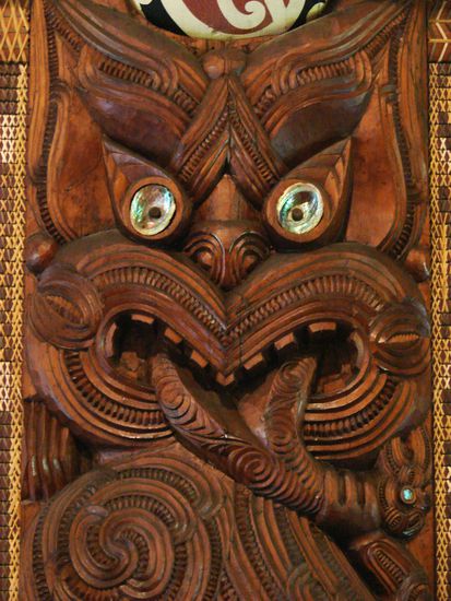 Typische Schnitzarbeit eines Gesichtes mit herausgestreckter Zunge.