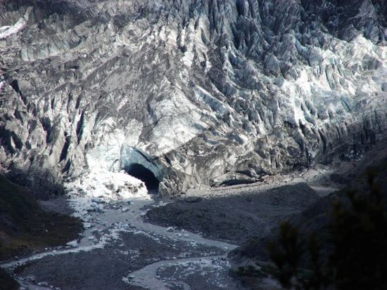 Am Ende der Gletscherzunge stroemt aus dem Gletschertor bestaendig Schmelzwasser hervor.
