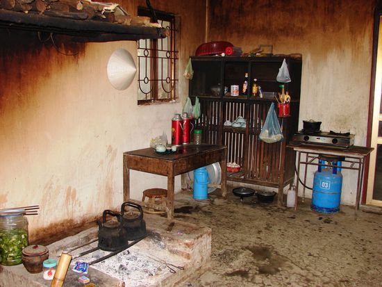 Gekocht wird am offenen Feuer. Da es keinen Abzug gibt entweicht der Rauch durch Fenster, Tueren und Loecher in den Waenden.