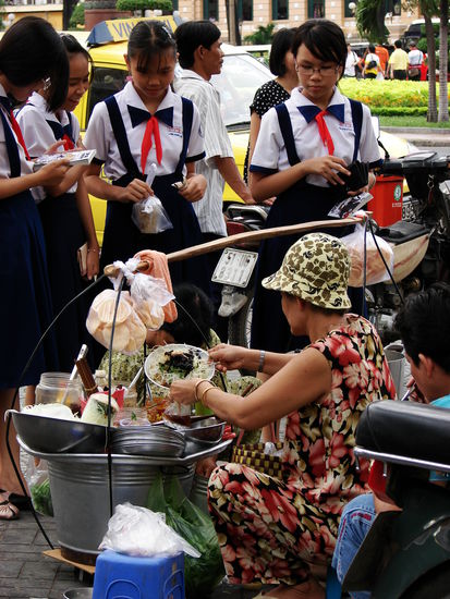 ... Schulkinder bei Strassenkuechen ihren Hunger stillen.