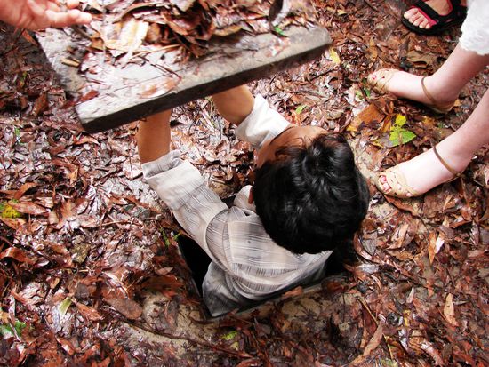 Durch derart gut versteckte und winzige Oeffnungen (vgl. europaeischen weiblichen Fuss rechts) stiegen die Vietnamesen in den Untergrund.