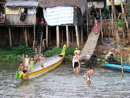 Badende Kinder winken den vorbeifahrenden Touristen freundlich zu.