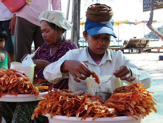 Am Strand bieten Frauen traumhafte Babylobster, 5 Stueck fuer einen Dollar, an.
