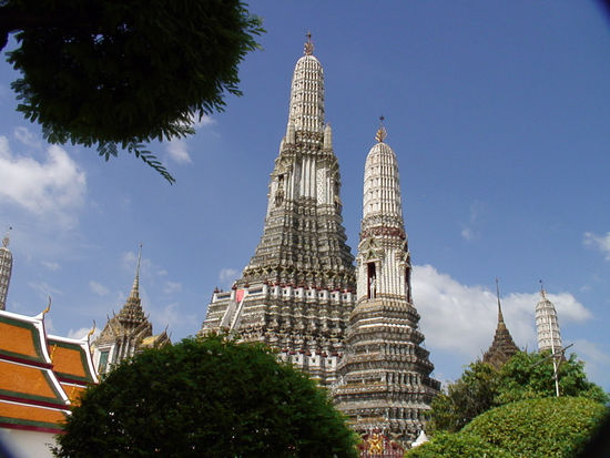 Die Prangs des Wat Arun vor dem blauen Vormittagshimmel.