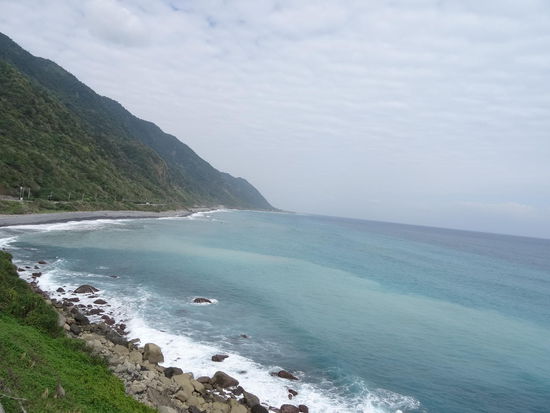 Steile grüne Berge fallen ins blaue Meer hinab