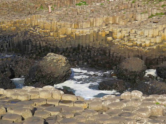 polygonale Basaltblöcke führen treppenförmig in den Atlantik