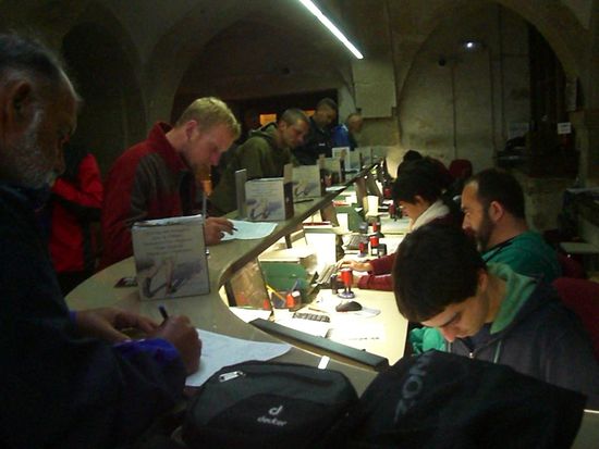 Die ehrenamtlichen Helfer in Akkordarbeit: von 8 Uhr morgens bis 21 Uhr abends stellen sie Pilgerurkunden (die "Compostela") aus.