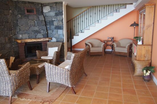 Eine Lounge mit Kamin, Fernseher und kleiner Bibliothek