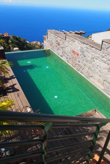 ein kleiner Infinity-Pool mit Sonnenliegen.