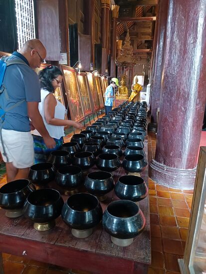 Gläubige können Münzen erwerben und spenden diese jeweils sorgsam in die 108 Mönchstöpfe.