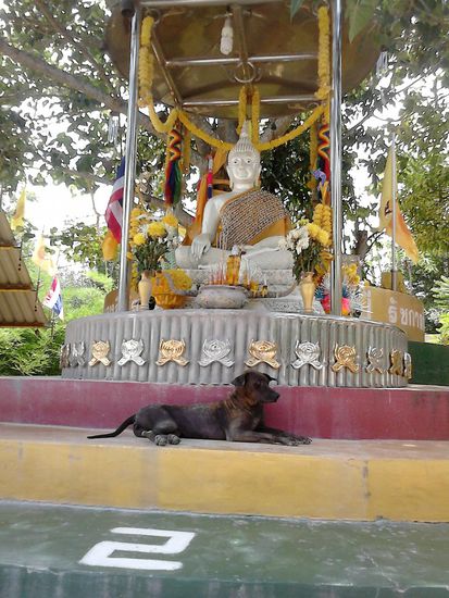Vor der Spitze: Drei Buddha-Statuen in Weiß, Silber und Gold, vor die man Räucherstäbchen in dort angebrachte Schalen stecken kann.