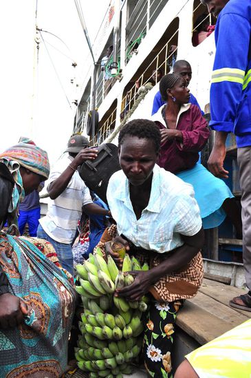 Bananen, Kokosnüsse und dutzende Säcke mit unbekanntem Inhalt werden im Boot gestapelt.