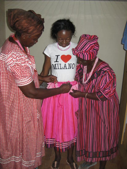 Die beiden alten Damen kleiden die Brau tfür die Kofferübergabezeremonie ein