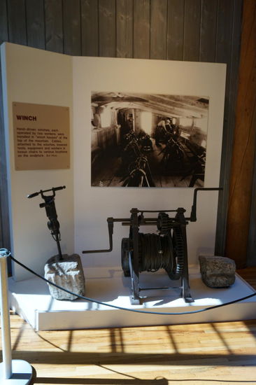Ein Bohrhammer und eine Winde.
Mit der von zwei Menschen bedienten Hand-Winde wurden das Handwerkszeug und die Arbeiter an die jeweilige Arbeitsstelle am Berg herunter gelassen.