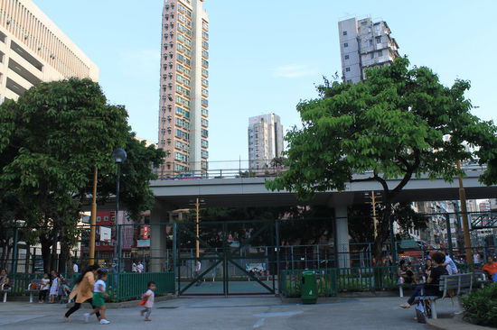 Kinderspielpaltz und Sportplatz umgeben von Autos, Strassen, Hochhaeusern und einem unglaublichen Laermpegel