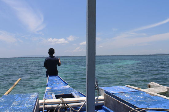 Unser "Kapitaen" wie er versucht den Katamaran durch das niedrige Wasser zu leiten ohne dass wir uns auf den Sandbaenken stranden