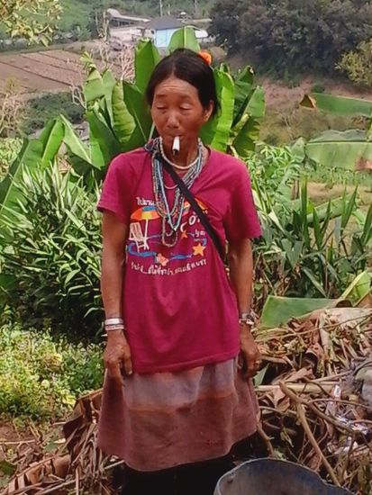 Welches kraut diese akha-frau wohl so genuesslich raucht?