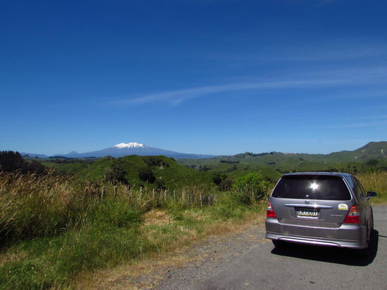 Da kommt man um die Kurve gefahren und da ist er auf einmal: Tongariro Nationalpark. Mit weißer Spitze Mt. Ruapehu und links daneben ganz klein der Schicksalsberg Mt. Ngaurahoe.